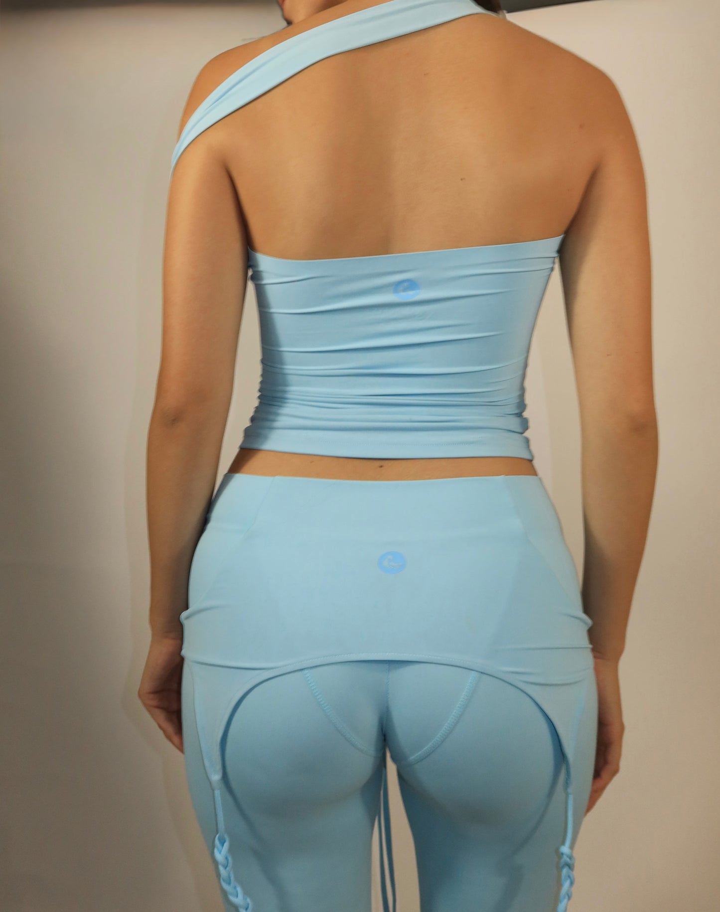 Person wearing a light blue athletic outfit on a neutral background
